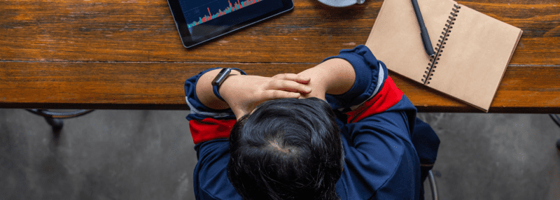 person at a desk with ipad and notebook